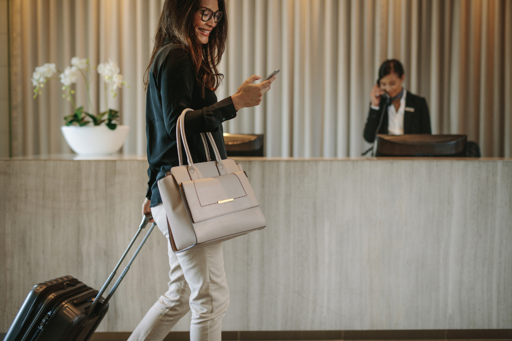 Personal Trainer in Switzerland happy travel client checking phone smiling luxury travel experience