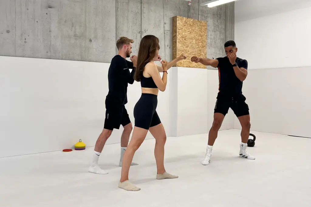 Personal Trainer Adil Semdaji giving instructions two clients duo boxing session small group training