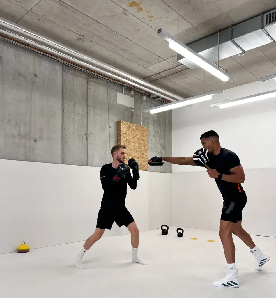 Personal Trainer indoor boxing session male client intensive training championship level instruction
